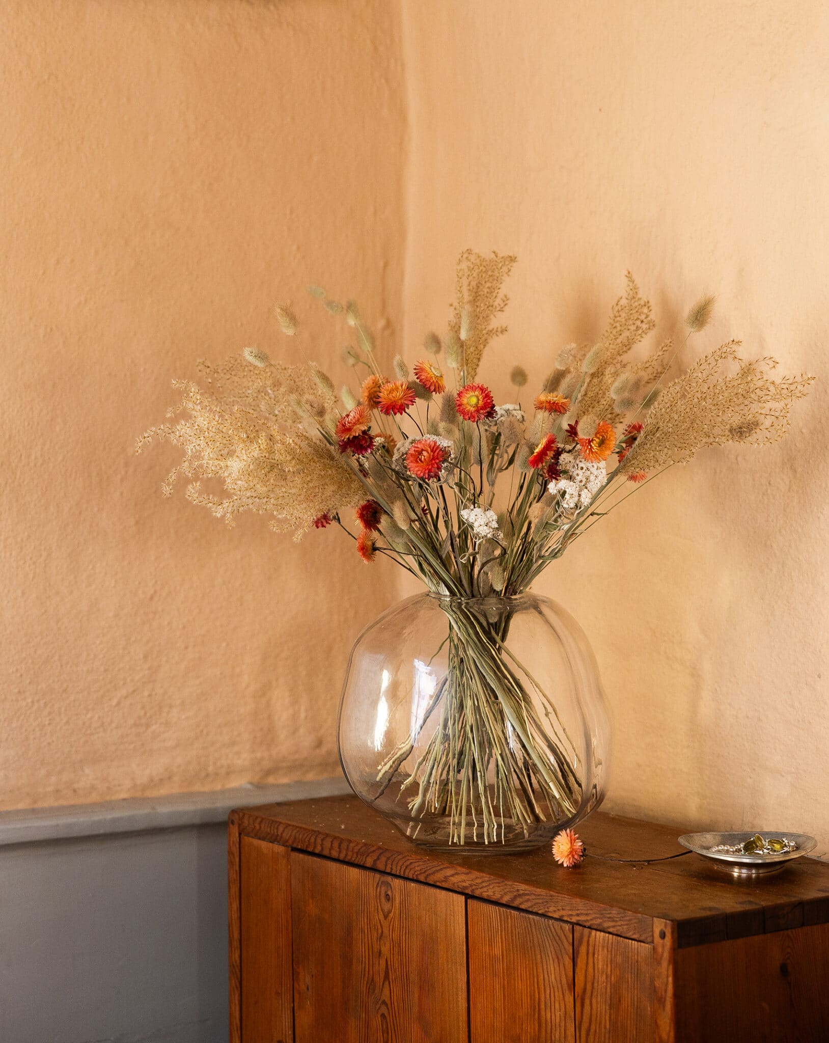 Bukett med torkade blommor i beige, vitt och aprikost.